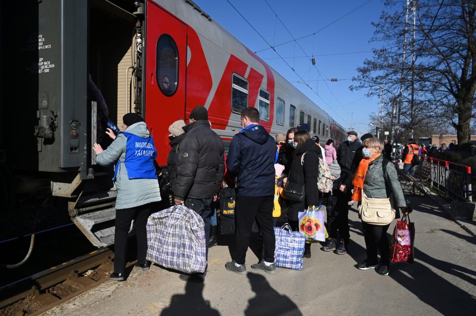 People from the Donetsk and Luhansk regions, the territory controlled by pro-Russia separatist governments in eastern Ukraine, get on a train to be taken to temporary residences in other regions of Russia, at the railway station in Taganrog, Russia, Monday, Feb. 21, 2022.