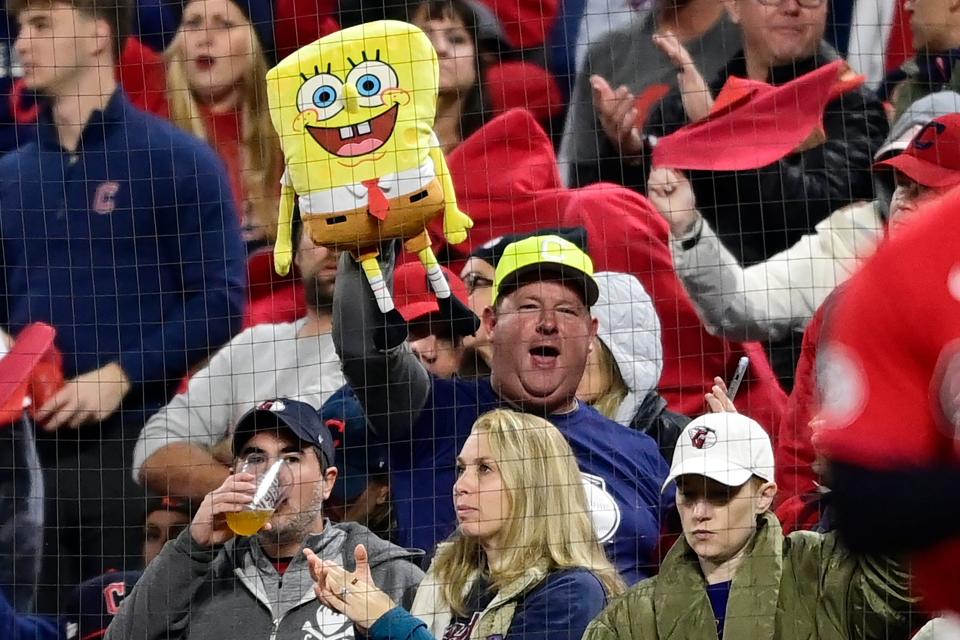 A Cleveland Guardians fan holds a SpongeBob SquarePants doll and cheers in the second inning of Game 4 of a baseball AL Division Series on Sunday against the New York Yankees.