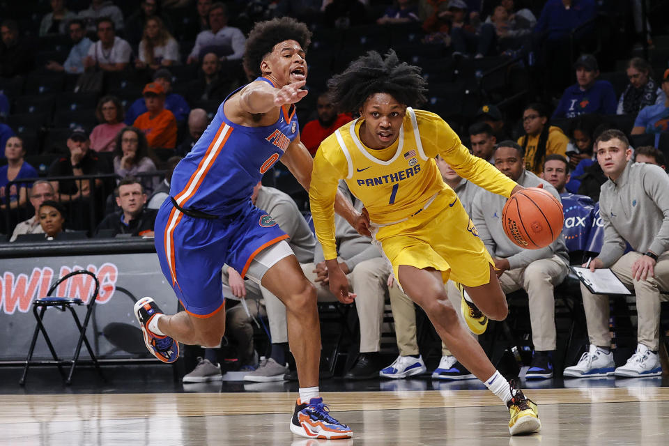 Pittsburgh guard Carlton Carrington (7) drives to the basket against Florida guard Zyon Pullin (0) during the first half of an NCAA college basketball game in the NIT Season Tip-Off at Barclay's center, Wednesday, Nov. 22, 2023, in New York. (AP Photo/Eduardo Munoz Alvarez)