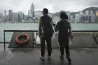 People stand by the shore as the Hong Kong Observatory raised its No.8 storm warning, in Hong Kong, Saturday, July 2, 2022. Typhoon Chaba is buffeting Hong Kong, bringing high winds and plenty of rain, but no serious damage, as of midday Saturday. (AP Photo/Kin Cheung)