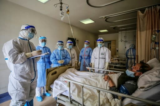 Medical staff speak with a patient infected by the COVID-19 illness at Red Cross Hospital in Wuhan, China