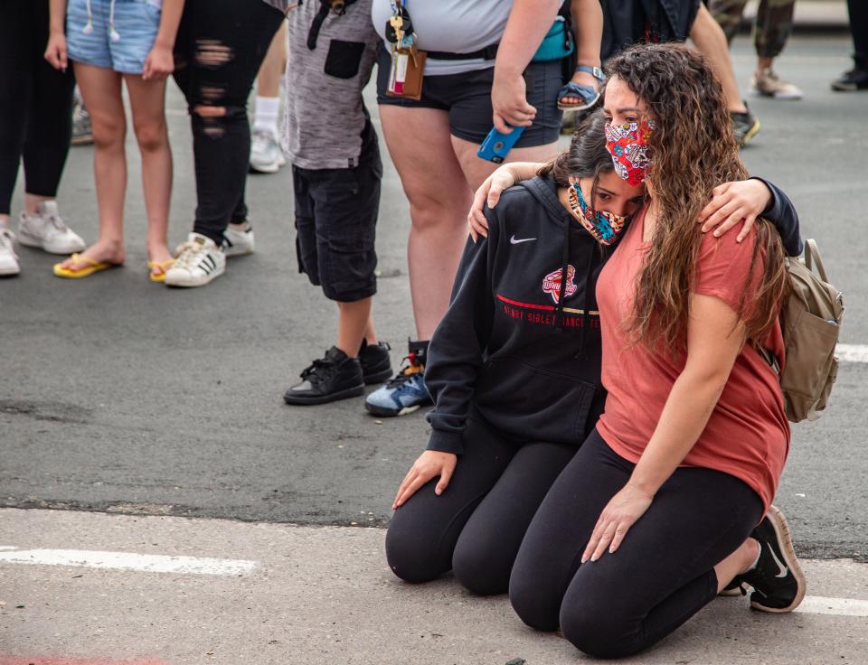 Catalina Martinez, 13, and her mother, Wendy Everett, of St. Paul, hold each other as they gather at a memorial for George Floyd in Minneapolis on Wednesday, May 27.