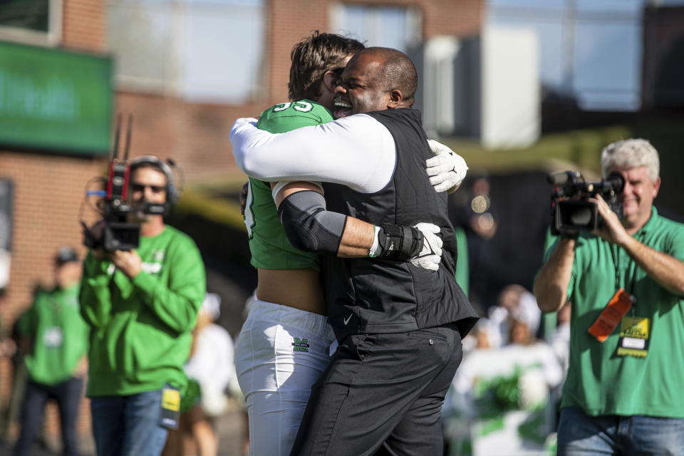 Marshall head coach Charles Huff hugs senior Owen Porter as he is introduced for senior day during an NCAA football game against Georgia State, on Saturday, Nov. 26, 2022, at Joan C. Edwards Stadium in Huntington W.Va./The Herald-Dispatch via AP)