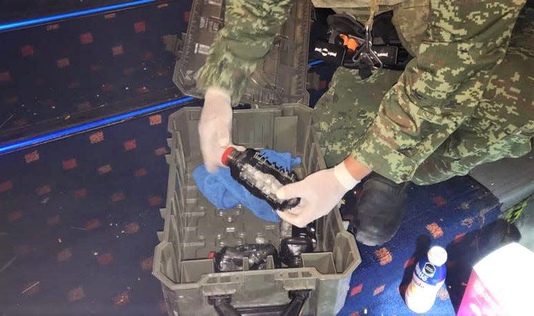 A Mexican army soldier inspects homemade bombs planted in a Cinépolis movie theater in the Gran Patio Zaragoza shopping mall in Juárez on May 19.