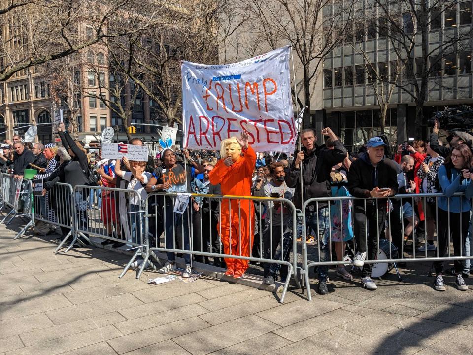 Anti-Trump demonstrators stand behind a metal barricade at the NYC courthouse before Donald Trump's arraignment