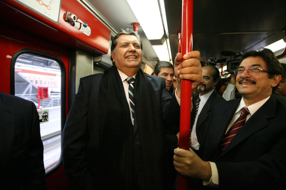 FILE - In this July 11, 2011 file photo, Peru's outgoing President Alan García, left center, rides the new Line 1 electrical train system, in Lima, Peru. Current Peruvian President Martinez Vizcarra said Garcia, the 69-year-old former head of state died Wednesday, April 17, 2019, after undergoing emergency surgery in Lima. Garcia shot himself in the head early Wednesday as police came to detain him in connection with a corruption probe. (AP Photo/Martin Mejia, File)