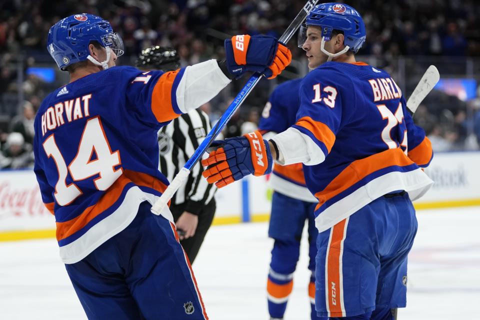 New York Islanders' Mathew Barzal (13) celebrates with teammate Bo Horvat (14) after scoring a goal during the second period of an NHL hockey game against the Arizona Coyotes Tuesday, Oct. 17, 2023, in Elmont, N.Y. (AP Photo/Frank Franklin II)