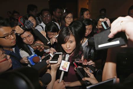 Louis Sidharta (C), a 25-year-old Indonesian whose fiance was onboard the AirAsia flight QZ8501, speaks to the media at a waiting area for next-of-kin and relatives at Changi Airport in Singapore December 28, 2014. REUTERS/Edgar Su