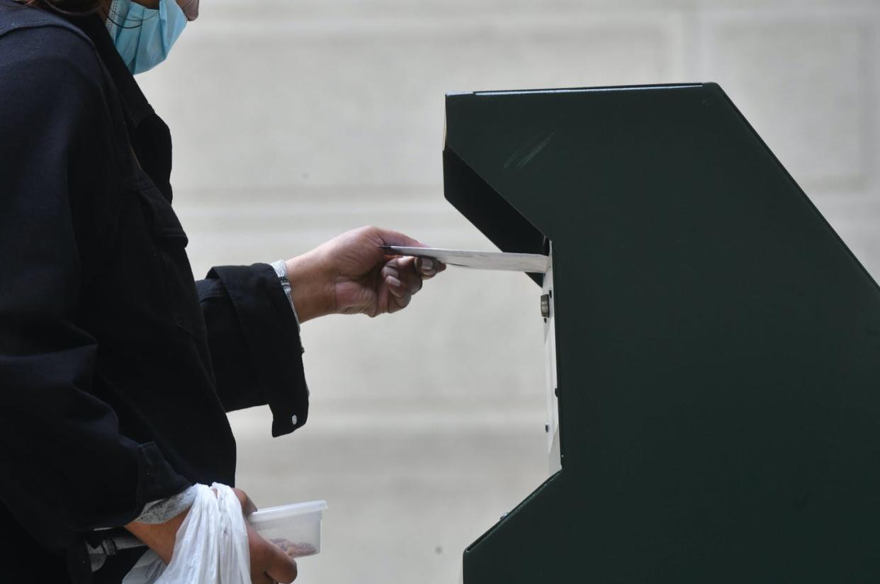 <span class="caption">As American voters cast their ballots, they are also being targeted with foreign disinformation.</span> <span class="attribution"><a class="link " href="https://www.gettyimages.com/detail/news-photo/woman-deposits-her-ballot-in-an-official-ballot-drop-box-at-news-photo/1229319816" rel="nofollow noopener" target="_blank" data-ylk="slk:Mark Makela/Getty Images;elm:context_link;itc:0;sec:content-canvas">Mark Makela/Getty Images</a></span>