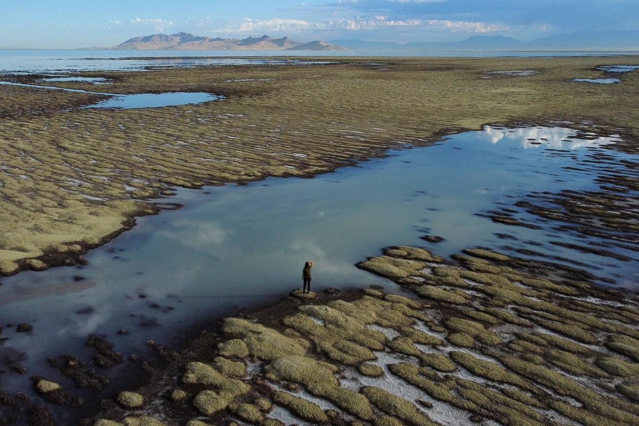 State of Utah Department of Natural Resources park ranger Angelic Lemmon walks across reef-like structures called microbialites, exposed by receding waters, at the Great Salt Lake, near Salt Lake City, on Sept. 28, 2022.