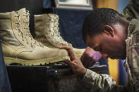 <p>A U.S. soldier from the 3rd Cavalry Regiment pays his respects during a memorial for Specialist Wyatt Martin and Sergeant First Class Ramon Morris at Bagram Air Field in the Parwan province of Afghanistan Dec. 23, 2014. Specialist Martin and Sergeant First Class Ramon were killed on December 12th by an improvised explosive device while on patrol near Bagram Air Field. (Photo: Lucas Jackson/Reuters) </p>