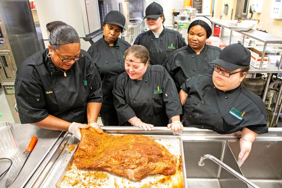 From left, chef instructor Shalisa Alexander and students Janelle West, Kayla Strohmeyer, Annemarie Roberts, Lashaunda Lynch and Victoria Rust prepare a brisket during cooking classes at the Kitchen School at the Food Bank of Delaware in Milford on Tuesday, July 11, 2023. The Milford branch offers specialized training in the food and hospitality industries for adults with disabilities, with the first-ever class out of the branch set to graduate on Thursday.