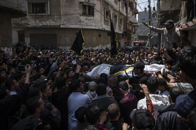 Mourners carry the bodies of Khalil Bahtini, the Islamic Jihad militant group's commander for the northern Gaza Strip, his wife and son, who were killed in an Israeli airstrike at their family home, during their funeral, in Gaza City, Tuesday, May 9, 2023. Bahtini was among three senior Islamic Jihad commanders killed in targeted airstrikes early Tuesday. Palestinian health officials said at least 10 others were killed, including wives of two of the militants, several of their children and others nearby. (AP Photo/Fatima Shbair)