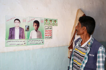 Abdullah al-Khawlani looks at posters of boys killed by last month's Saudi-led air strike that killed dozens including children in Saada, Yemen September 4, 2018. A son of al-Khawlani was among those killed by the strike. Picture taken September 4, 2018. REUTERS/Naif Rahma