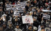 Spectators hold signs reading "Stay in Oakland" in reference to the Oakland Raiders proposed move to Los Angeles during the Raiders NFL football game against the San Diego Chargers at Oakland Coliseum in this December 25, 2015 file photo. Mandatory Credit: Kirby Lee-USA TODAY Sports/Files