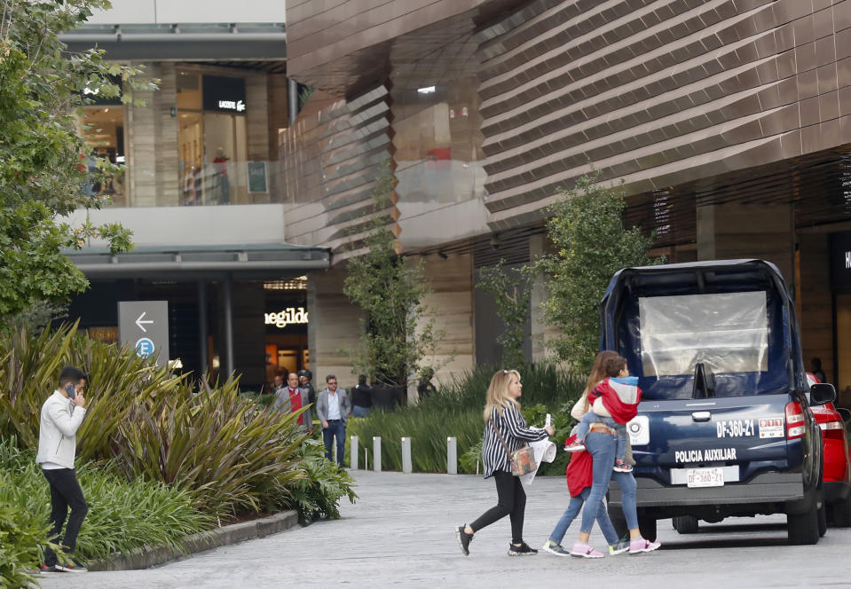 People leave an upscale shopping mall in the south of Mexico City, Wednesday, July 24, 2019, where a woman wearing a blond wig disguise killed two Israeli men. Authorities said the woman and another man sat down at a table near the victims before she rose and shot the two Israelis at close range. According to Mexico City police chief Jesus Orta the woman said, "she had a sentimental relationship with one of the victims, who she met on social media, and that the attack was due to infidelity." (AP Photo)