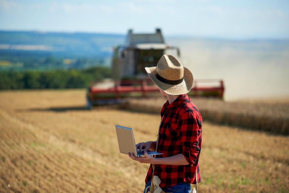 A man holding a computer in a field