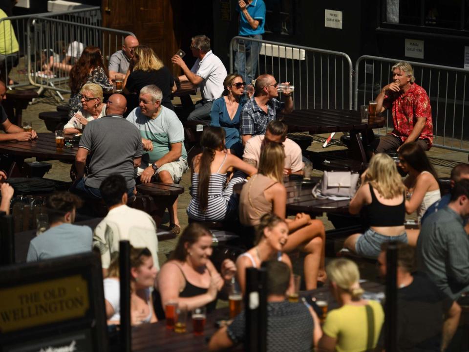People sit with drinks outside a pub in the centre of Manchester, 31 July 2020: Oli Scarff/AFP via Getty Images