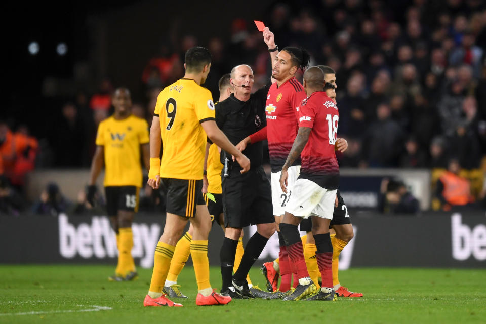 Ashley Young receives his second red card from Mike Dean.