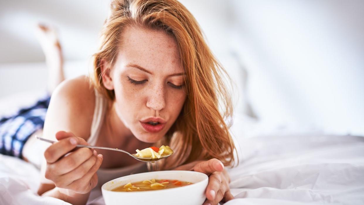 blowing on soup to cool it down in bed
