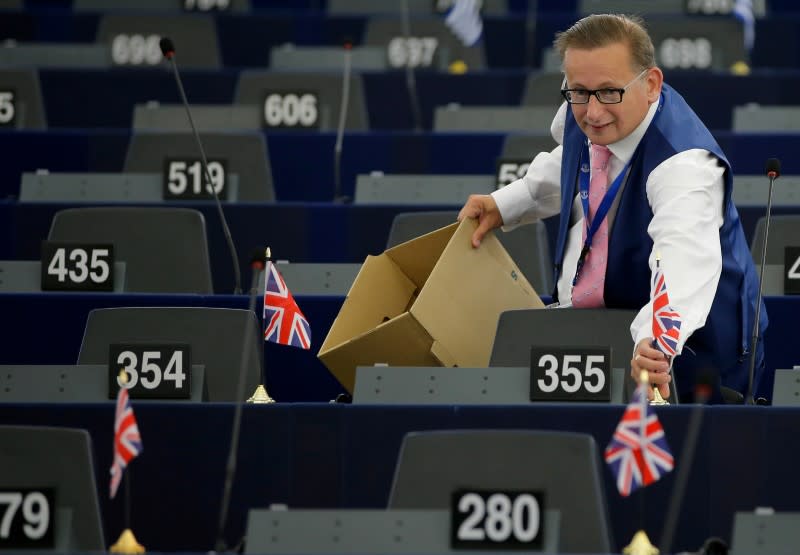 FILE PHOTO: UKIP member Finch puts British Union Jack flags on the desks of fellow members of the Europe of Freedom and Direct Democracy Group of the European Parliament, ahead of a debate in Strasbourg