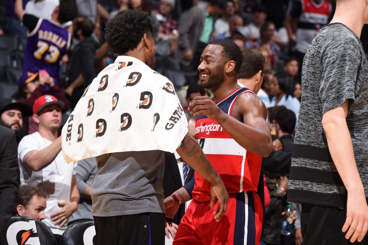 John Wall smiles and embraces former teammate Nick Young after the Wizards clinch the Southeast Division title. (Getty Images)