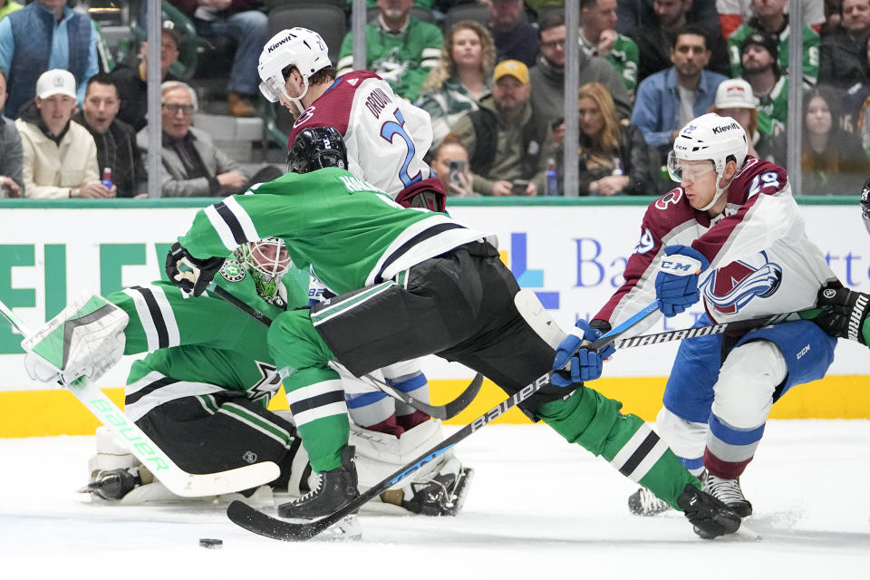 Dallas Stars goaltender Scott Wedgewood, left, eyes the puck as teammate defenseman Jani Hakanpaa (2) helps defend against the attack of Colorado Avalanche left wing Jonathan Drouin (27) and center Nathan MacKinnon (29) during the first period of an NHL hockey game, Thursday, Jan. 4, 2024 in Dallas. (AP Photo/Julio Cortez)