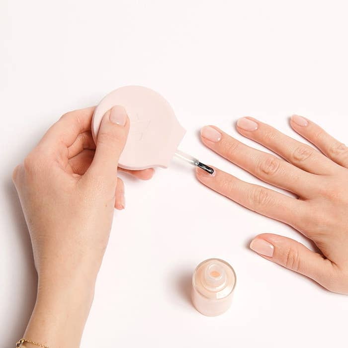 a model painting their nails with the tool