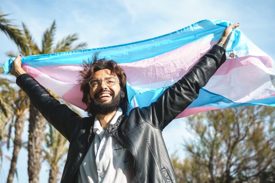 man waving a transgender flag