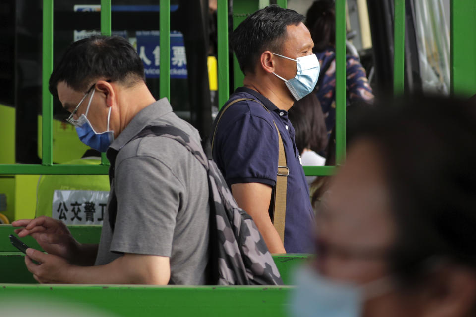 Commuters wearing protective face masks to help curb the spread of the new coronavirus line up to board a bus at a bus terminal in Beijing, Monday, June 22, 2020. A Beijing government spokesperson said the city has contained the momentum of a recent coronavirus outbreak that has infected a few hundreds of people, after the number of daily new cases fell to single digits. (AP Photo/Andy Wong)