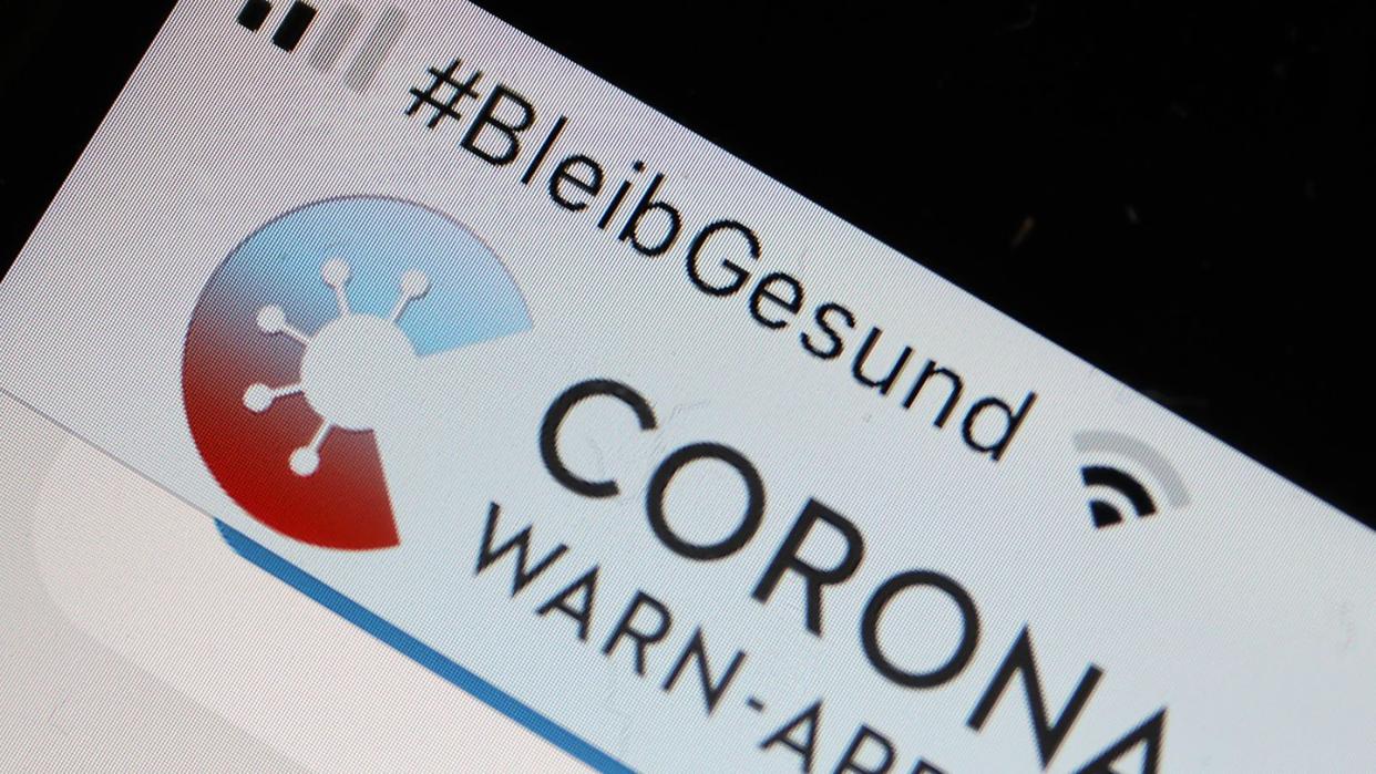 Die Corona-Warn-App mit der Seite zur Risiko-Ermittlung ist im Display eines Smartphone zu sehen.