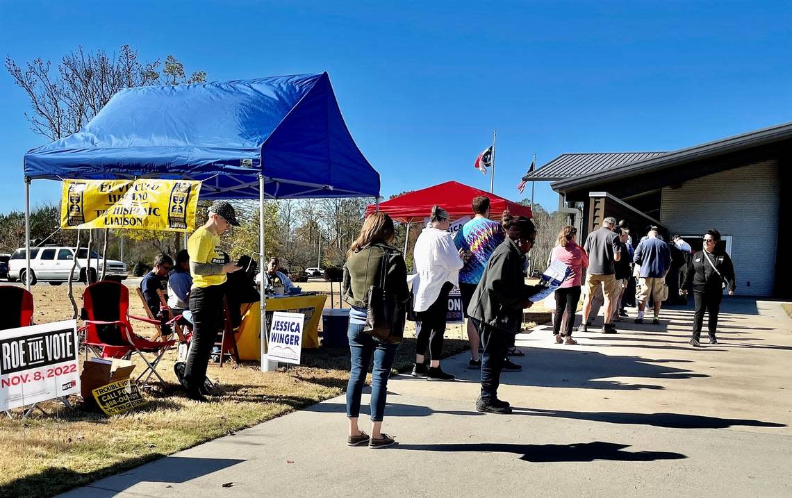 Pittsboro voters wait between a gauntlet of campaign booths Tuesday to cast their votes at the Chatham County Agriculture & Conference Center. The wait to vote was about 30 minutes at midday.