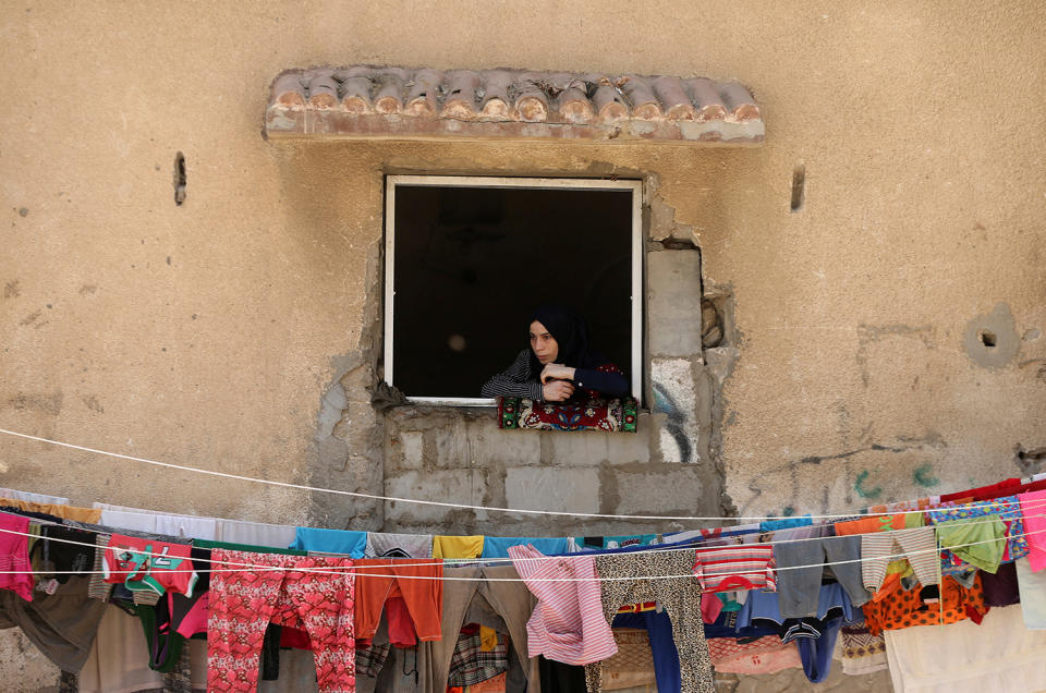 <p>A woman looks out of a house window as she watches the funeral of Palestinian fisherman Mohammed Baker in Gaza City May 16, 2017. (Photo: Mohammed Salem/Reuters) </p>