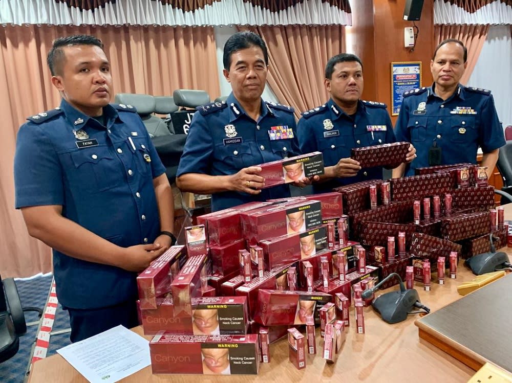 Johor Customs Department director Datuk Mohammad Hamidan Maryani (2nd left) with the contraband cigarettes during the media conference at Menara Kastam Johor in Johor Baru September 17, 2019. — Picture by Ben Tan