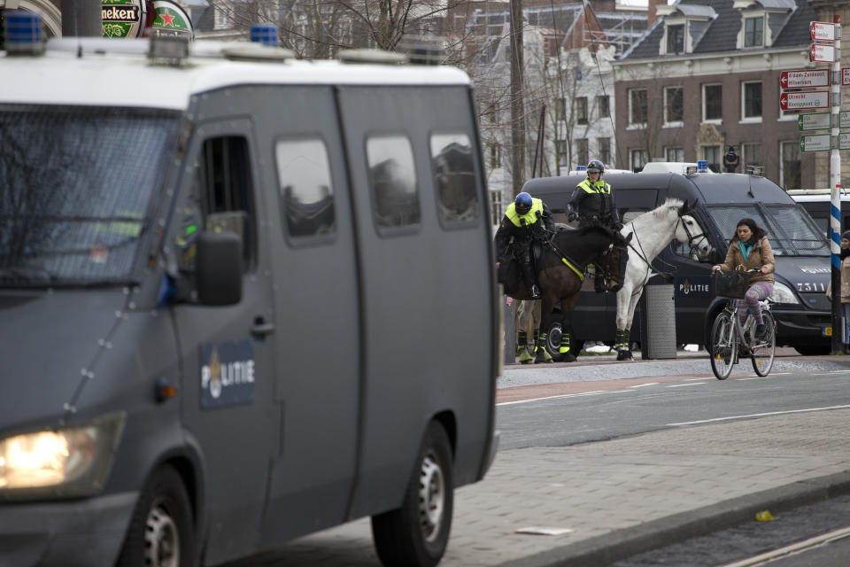 Dutch police keeps a distance as several hundred demonstrators in yellow vests march during a peaceful demonstration in Amsterdam, Netherlands, Saturday, Dec. 8, 2018. The French yellow vest protest movement is crossing borders, with demonstrations planned in neighboring Belgium and in the Netherlands. Neither country has proposed a hike in fuel tax, the catalyst for the massive and destructive demonstrations in France in recent weeks. (AP Photo/Peter Dejong)