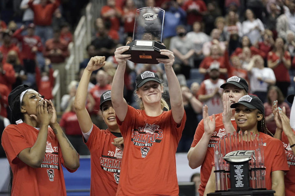 North Carolina State center Elissa Cunane, center, lifts the most valuable player trophy following an NCAA college basketball championship game against Miami at the Atlantic Coast Conference women's tournament in Greensboro, N.C., Sunday, March 6, 2022. (AP Photo/Gerry Broome)