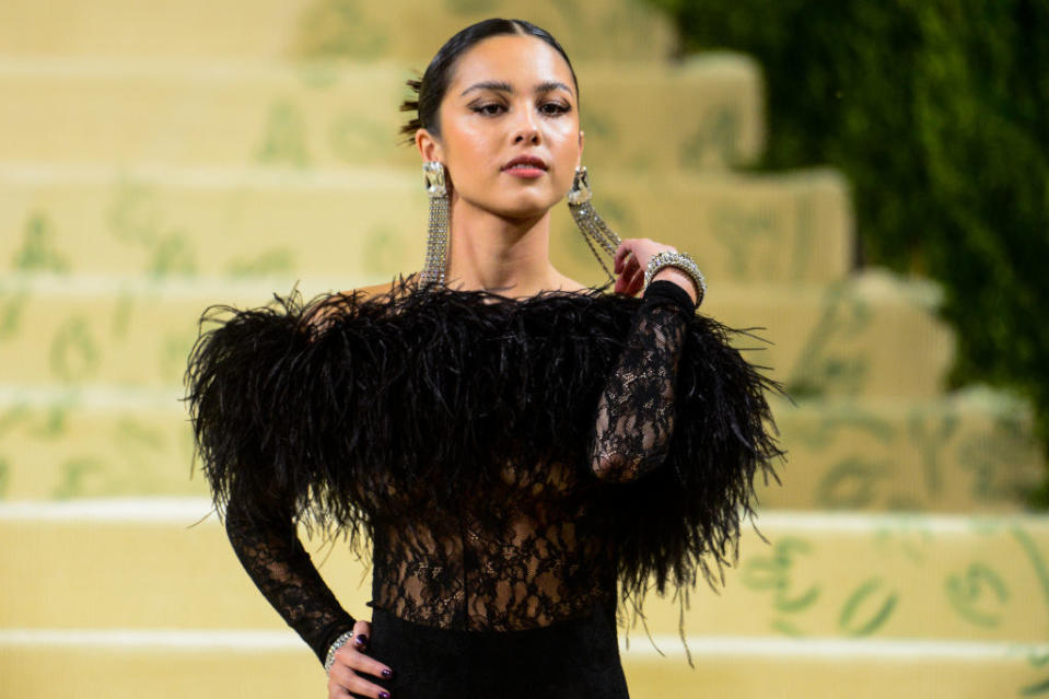 Olivia channeled the flapper era with ease in her all-black feathered look — complete with smoky eye makeup, shoulder-length silver earrings, and chunky silver bracelet. What more can you ask for?