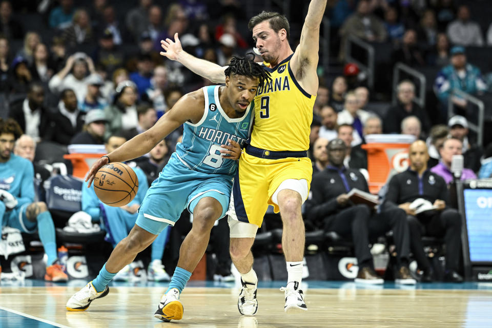 Charlotte Hornets guard Dennis Smith Jr. (8) attempts to drive past Indiana Pacers guard T.J. McConnell (9) during the first half of an NBA basketball game, Monday, March 20, 2023, in Charlotte, N.C. (AP Photo/Matt Kelley)