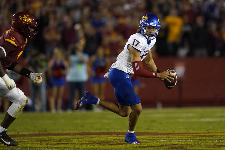 Kansas quarterback Jason Bean (17) runs from Iowa State defensive end Will McDonald IV (9) during the first half of an NCAA college football game, Saturday, Oct. 2, 2021, in Ames, Iowa. (AP Photo/Charlie Neibergall)