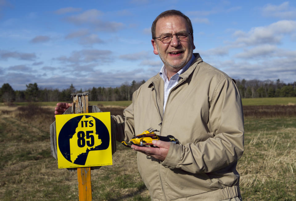 In this photo made Thursday, Nov. 15, 2012, Bob Myers, executive director of the Maine Snowmobile Association, stands next to a sign marking interstate snowmobile trail 85 in Augusta, Maine. FirstWind and other wind power companies in Maine are working with snowmobilers' groups to make their sites destinations for winter sledders via 600 miles of trails that are mostly there already. (AP Photo/Robert F. Bukaty)