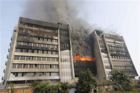 Smoke rises from a fire burning at a Standard Group garment factory in Gazipur November 29, 2013. There were no reports of casualties in the fire. REUTERS/Andrew Biraj