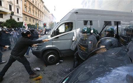 A protester clashes with Guardia di Finanza as they respond to a protest in front of the Ministry of Finance building in downtown Rome