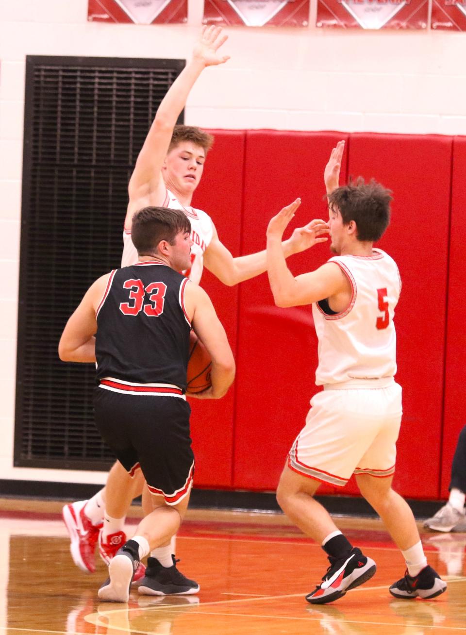 Coshocton's Coby Moore is defended by Sheridan's Evan Anderson (11) and Kory Holden (5) during Friday's game. The Generals won 63-35.