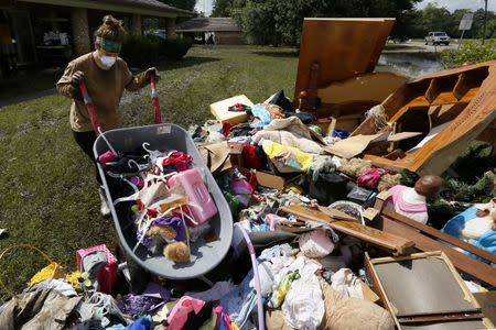 Melissa Gouda removes flood damaged items out of a friend's house in St. Amant, Louisiana. REUTERS/Jonathan Bachman