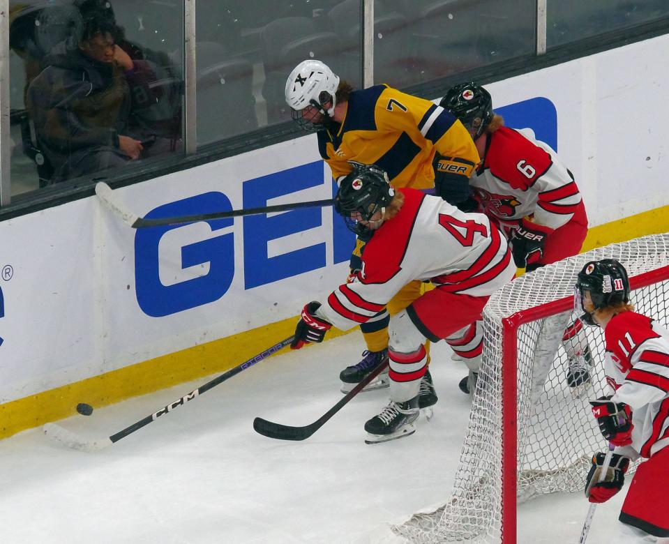 Xaverian's Liam Capplis (#7) fights for the puck in between  Pope Francis' Jacob Petrin (#4) and Matt Bolduc (#6) at the TD Garden on Sunday, March 19, 2023.