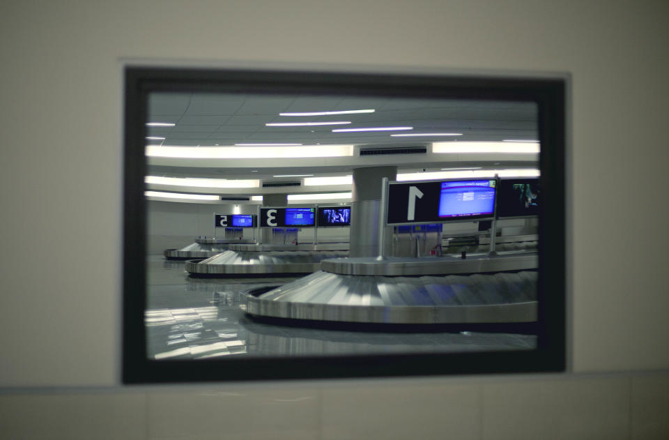 The baggage claim area is seen reflected in one way glass of a U.S. Customs office at the new Maynard Holbrook Jackson Jr. International Terminal at Atlanta's airport Wednesday, March 28, 2012. The new $1.4 billion international terminal at the world's busiest airport will be a sleek launching pad for millions of passengers that’s designed to help Atlanta grab a growing share of the lucrative market for global travelers. (AP Photo/David Goldman)