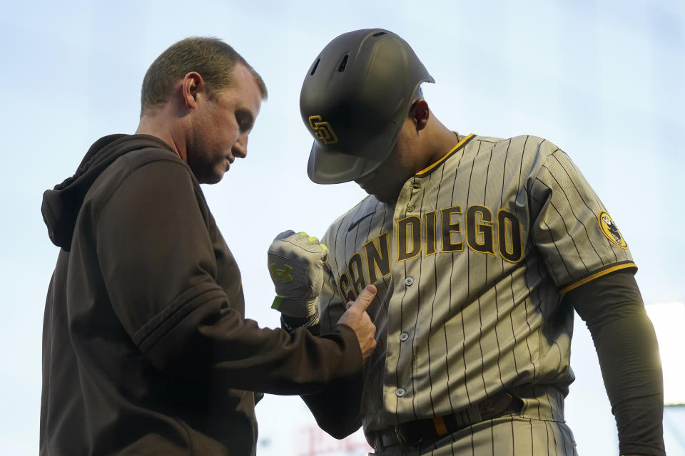 San Diego Padres' Juan Soto, right, is checked after being hit by a foul ball in the on-deck circle during the first inning of a baseball game against the San Francisco Giants in San Francisco, Monday, Sept. 25, 2023. (AP Photo/Jeff Chiu)