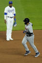 Detroit Tigers' Miguel Cabrera rounds the bases past Kansas City Royals third baseman Kelvin Gutierrez after hitting a grand slam during the seventh inning of a baseball game Friday, May 21, 2021, in Kansas City, Mo. (AP Photo/Charlie Riedel)