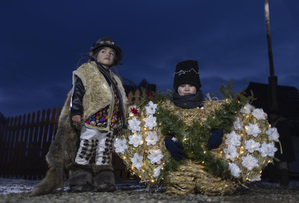 Children, dressed in traditional costumes, pose for a photo while celebrating the Malanka festival in the village of Krasnoilsk, Ukraine, Thursday, Jan. 13, 2022. Dressed as goats, bears, oxen and cranes, many Ukrainians rang in the new year last week in the colorful rituals of the Malanka holiday. Malanka, which draws on pagan folk tales, marks the new year according to the Julian calendar, meaning it falls on Jan. 13-14. In the festivities, celebrants go from house to house, where the dwellers offer them food. (AP Photo/Ethan Swope)