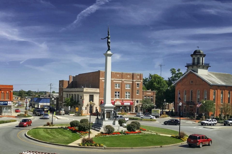 In this Sept, 15, 2015 photo, U.S. Route 20 enters the city and goes around the Civil War Monument, in Angola, Ind., known as the mound, that was erected in 1917. Angola is the Steuben County seat, with its courthouse on the left. The Historic Route 20 Association is hoping to encourage travelers to visit small towns along the old Route 20 highway with a historic designation. (Bryan Farr via AP)